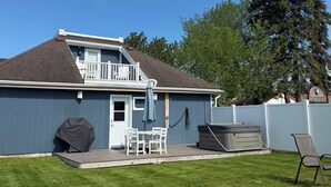 Una casa con terraza, una parrilla techada y un jacuzzi.