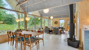 A spacious living area with a large wooden dining table, comfortable seating, and a fireplace. - 3 bedroom gorgeous home in Silkeborg (Silkeborg)