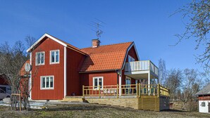 A red wooden house with a balcony and a chimney. - Gorgeous home in Strängnäs with sauna (Strängnäs)