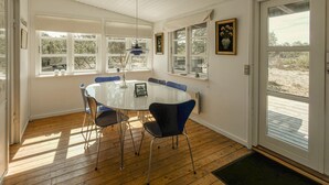 A dining area with a round table, chairs, and a view through large windows. - Lovely home in Anholt with WiFi (Anholt)