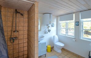 Bathroom features a shower, sink, and toilet, with a window for natural light.