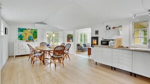 A spacious kitchen with a dining area, white cabinetry, and a large window. - Beautiful home in Melby with kitchen (Melby)