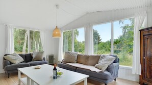 A cozy room with a white table, two sofas, and a hanging light fixture. - Beautiful home in Melby with kitchen (Melby)