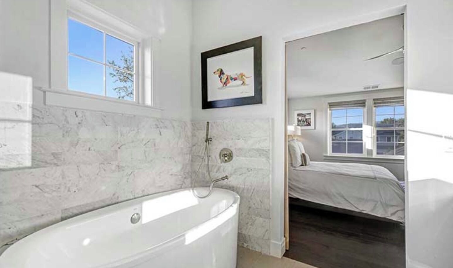 Un baño moderno con una bañera independiente, ducha y un ventanal que proporciona luz natural.