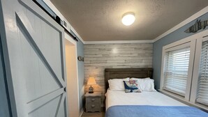 Une chambre à coucher avec un lit, une table de chevet, une lampe et une horloge murale.
