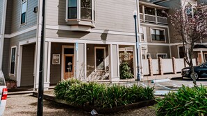 A two-story residential building with a bay window, a front porch, and a small garden area. - Boardwalk Loft w/bay view loacated in old town (Eureka)