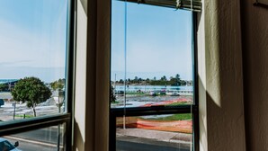 A view from a window with a view of a road, a tree, and a body of water. - Boardwalk Loft w/bay view loacated in old town (Eureka)