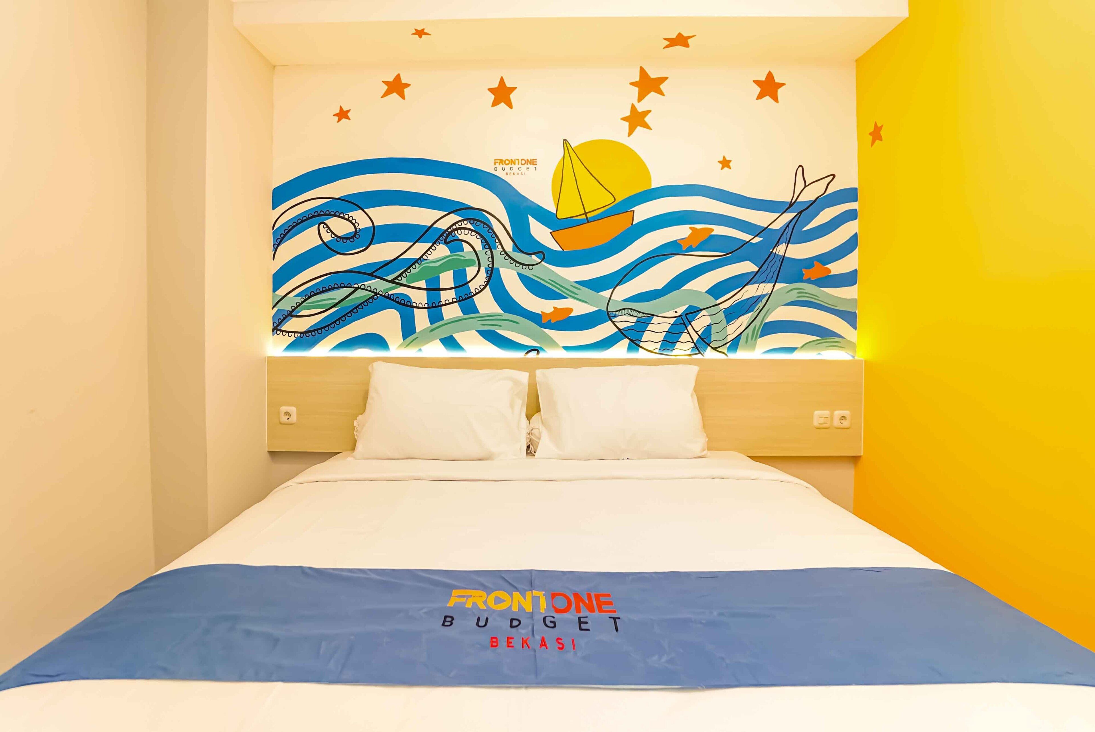 A hotel room with a bed, a wall mural, and a bedspread with text.