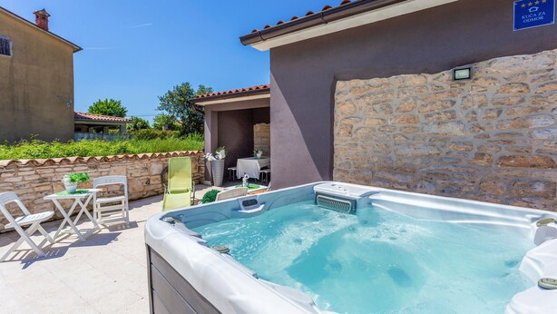 A hot tub area with a stone wall, a small table with chairs, and a sign indicating a guest room. - 4 bedroom lovely home in Hrboki (Hrboki)