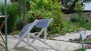 Un fauteuil de jardin blanc à rayures bleues.