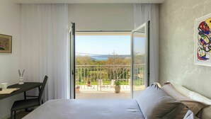 A hotel room with a bed, a desk, and a balcony with a view of the landscape. - Private Villa with A/C, private pool, WIFI, hot tub, TV, terrace, pets allowed, panoramic view (Valhova)
