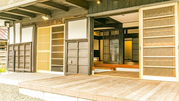 Un edificio japonés tradicional con puertas correderas y una terraza de madera.