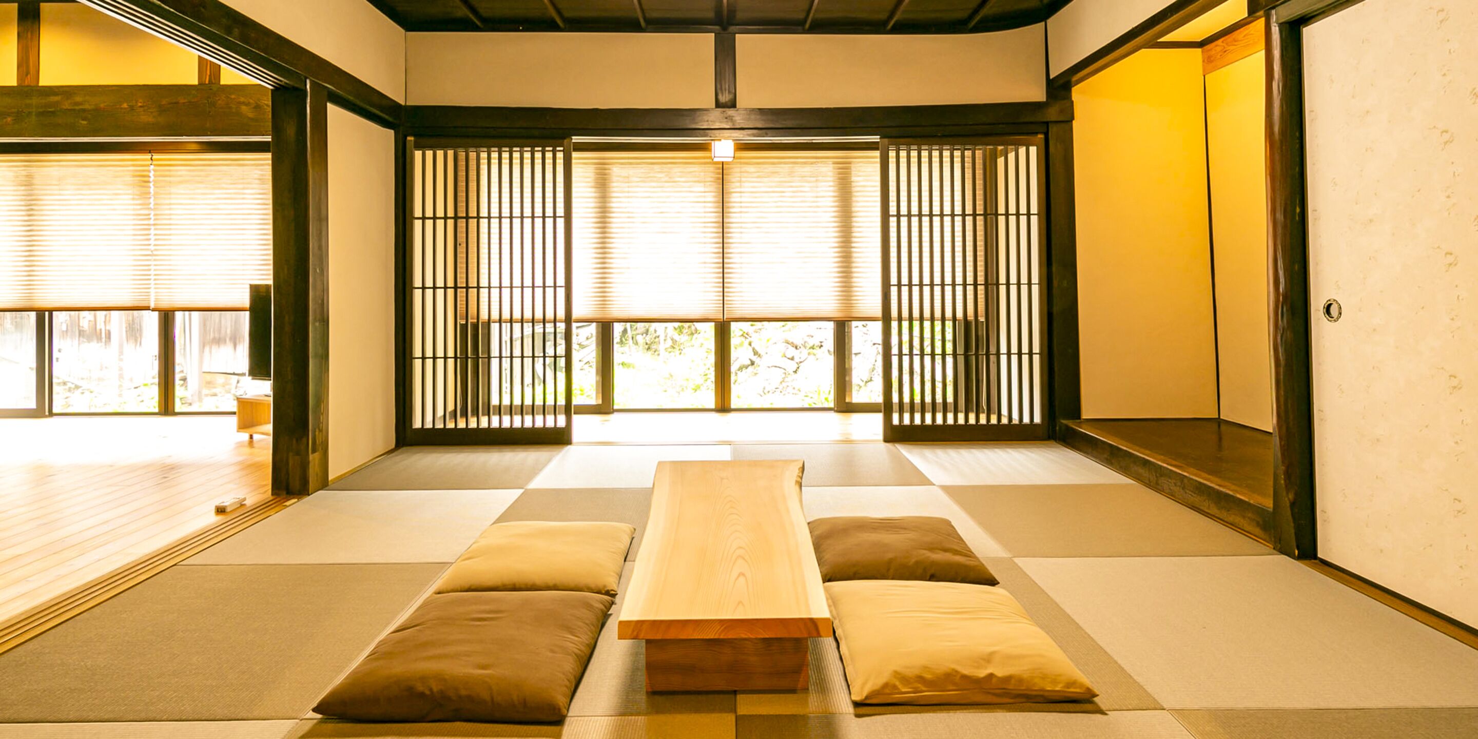 A traditional Japanese room with tatami flooring, a low wooden table, and sliding doors.