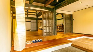Un interior japonés tradicional con suelo de tatami, puertas correderas y un zapatero.