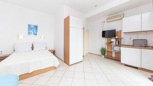 A modern hotel room with a bed, bedside table, and a TV.