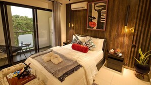 A modern bedroom with a large bed, a nightstand, a potted plant, and a balcony with a table and chair. - Spacious 2BR Penthouse Apt close to Airport with pool & gym (Accra)