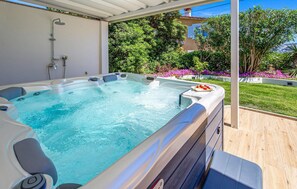 A hot tub with a built-in showerhead, surrounded by a wooden deck and lush greenery. - Gorgeous home in Lopar with WiFi (Lopar)