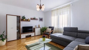Una sala de estar moderna con un sofá, televisor y una mesita de centro.