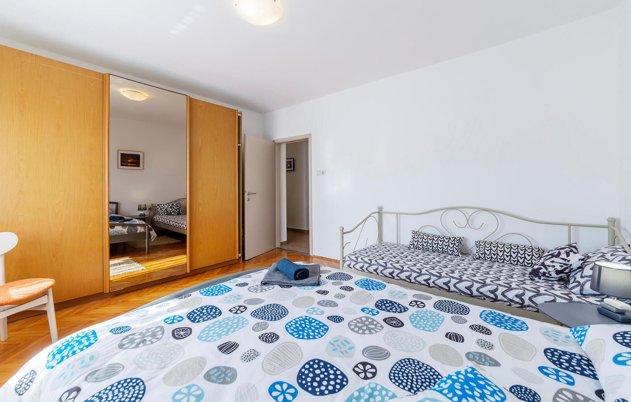 Une chambre à coucher comprenant un lit, une chaise, une armoire et un bureau.