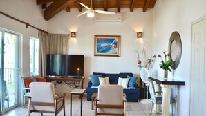 A living room with a TV, sofa, chairs, and a fireplace. - Beachfront Villa Casa Mar de Grecia 2 (Punta de mita)
