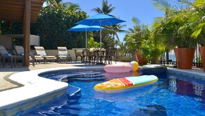 A pool area with lounge chairs, umbrellas, and inflatable toys. - Beachfront Villa Casa Mar de Grecia 2 (Punta de mita)