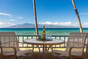 Relax with a view of the tranquil beach and distant mountains from this serene outdoor seating area.
