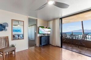 Relax in this living room with a television and ocean views from the large window.