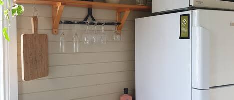 A kitchen with a stainless steel sink, wooden countertop, and a white refrigerator.