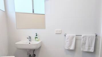 Un bagno moderno con il water, un lavandino e uno specchio.