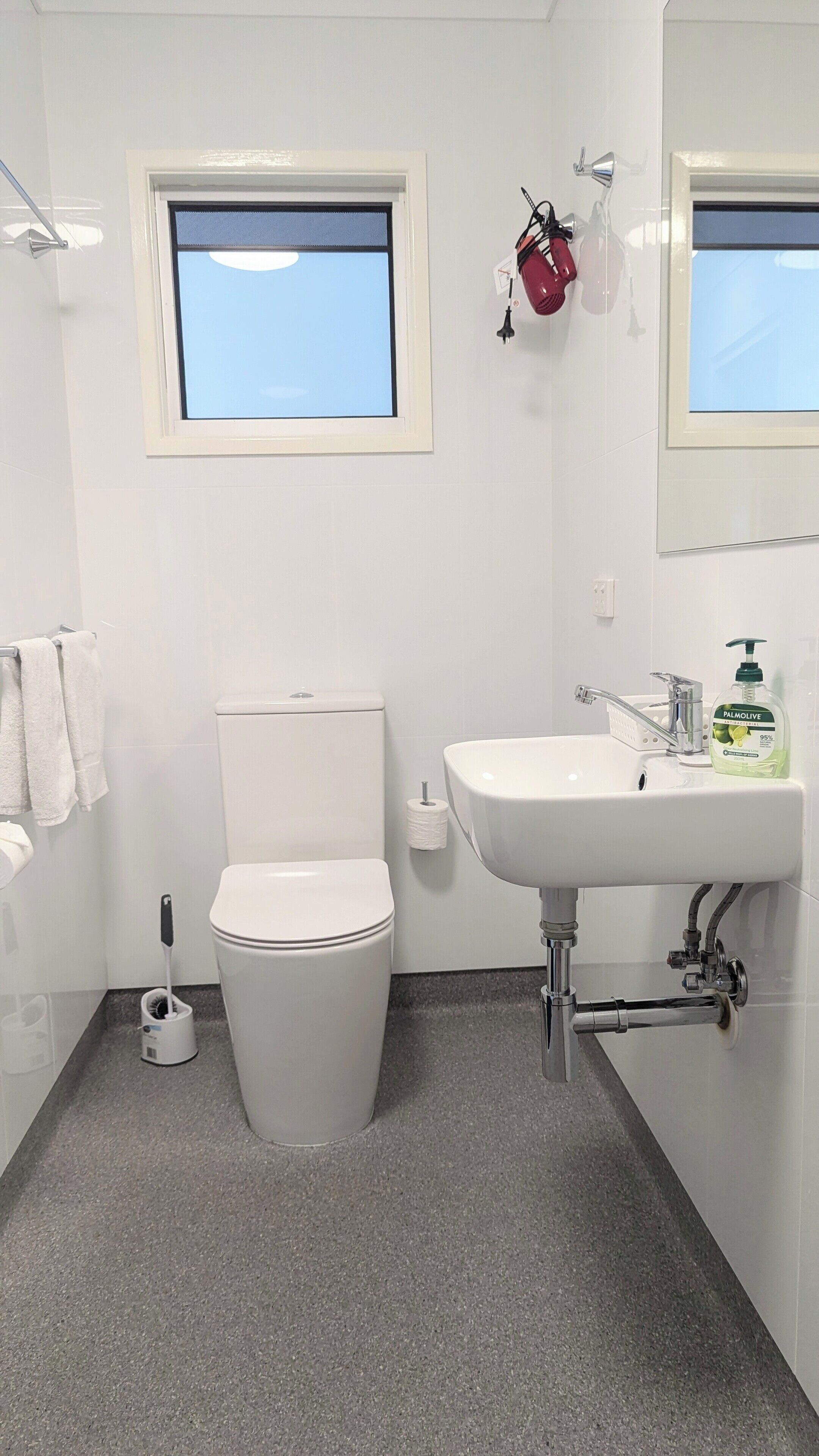 Un baño con inodoro, lavamanos y ventana.
