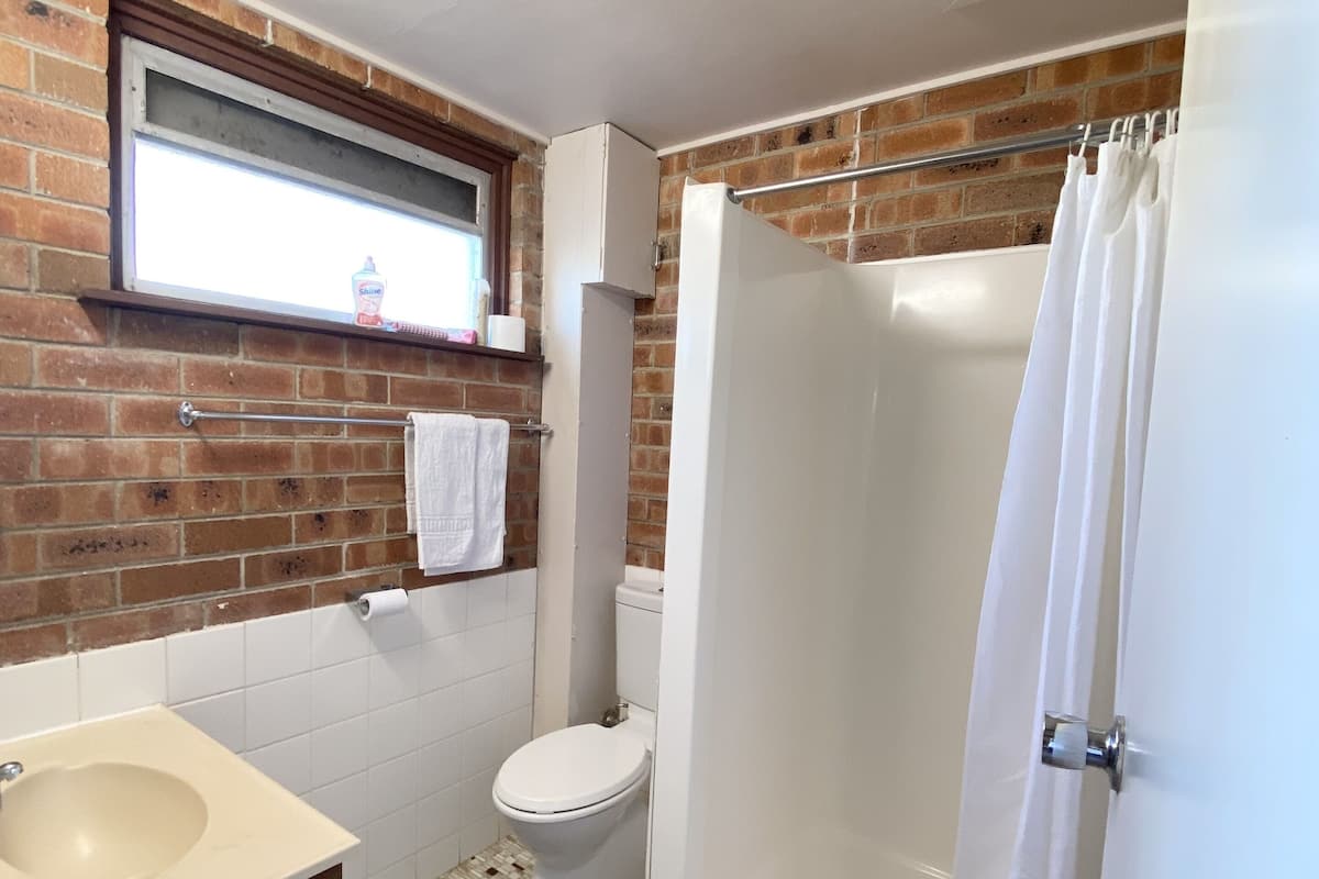 A bathroom with a toilet, sink, and shower.