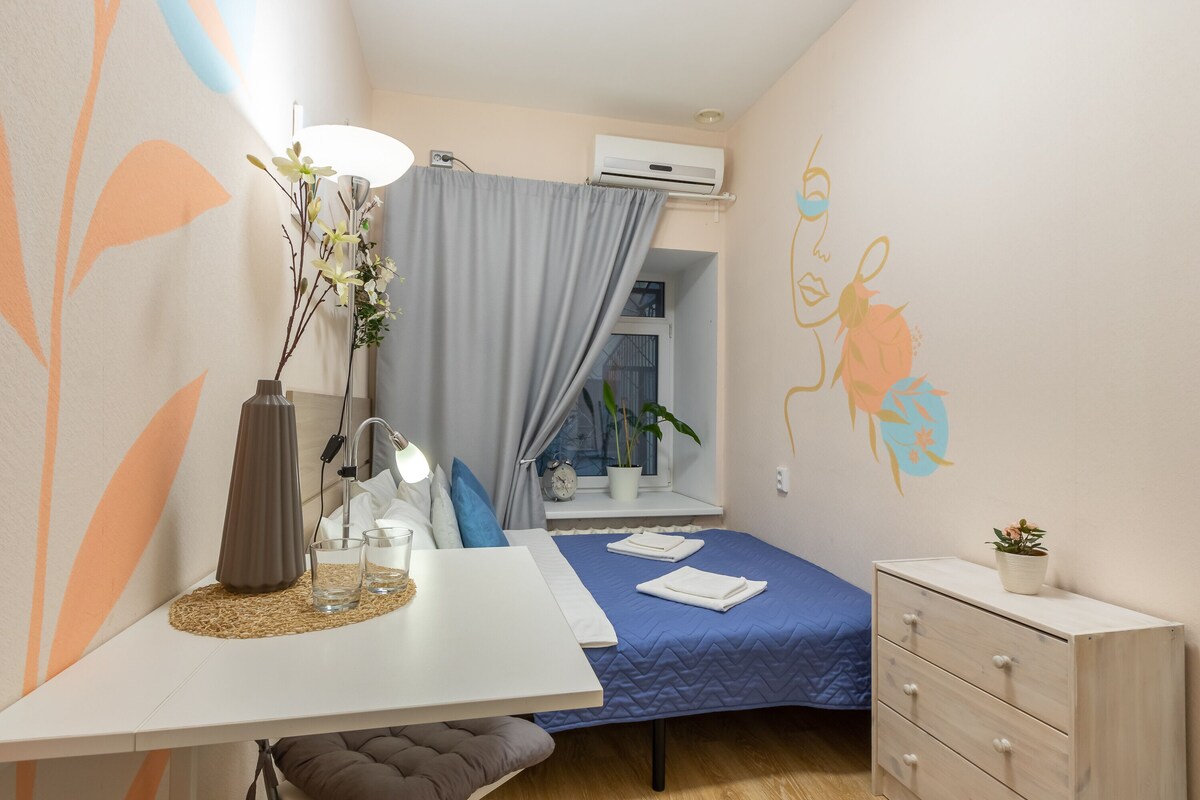 Une chambre à coucher de taille modeste, comprenant un lit, une table de chevet, une lampe et une petite commode.