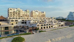 Ein Resort mit mehreren Gebäuden, einem Schwimmbad und einer Strandanlage.