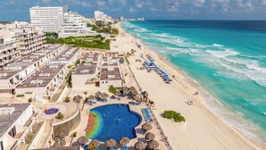 Ein Küstenhotel mit großem Pool, Zugang zum Strand und Meerblick.