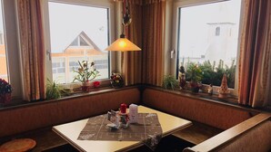 A cozy corner with a table, bench, and potted plants. - Brauneggerhof Gasthof Mayer (Raxendorf)