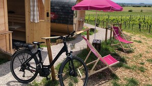 Una estructura de madera con una bicicleta y una silla rosa.