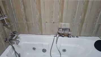 Ducha, bañera de hidromasaje, toallas y jabón