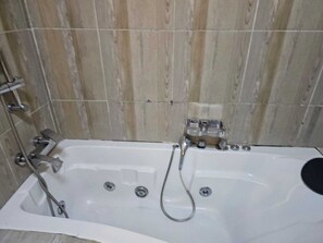 Ducha, bañera de hidromasaje, toallas y jabón