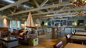 A spacious interior with a high ceiling, a bar area, and seating arrangements. - Luxury Loch Lomond Lodge (Alexandria)