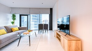 Ein modernes Wohnzimmer mit einer Couch, einem Couchtisch und einem Fernseher auf einem Holzboden.