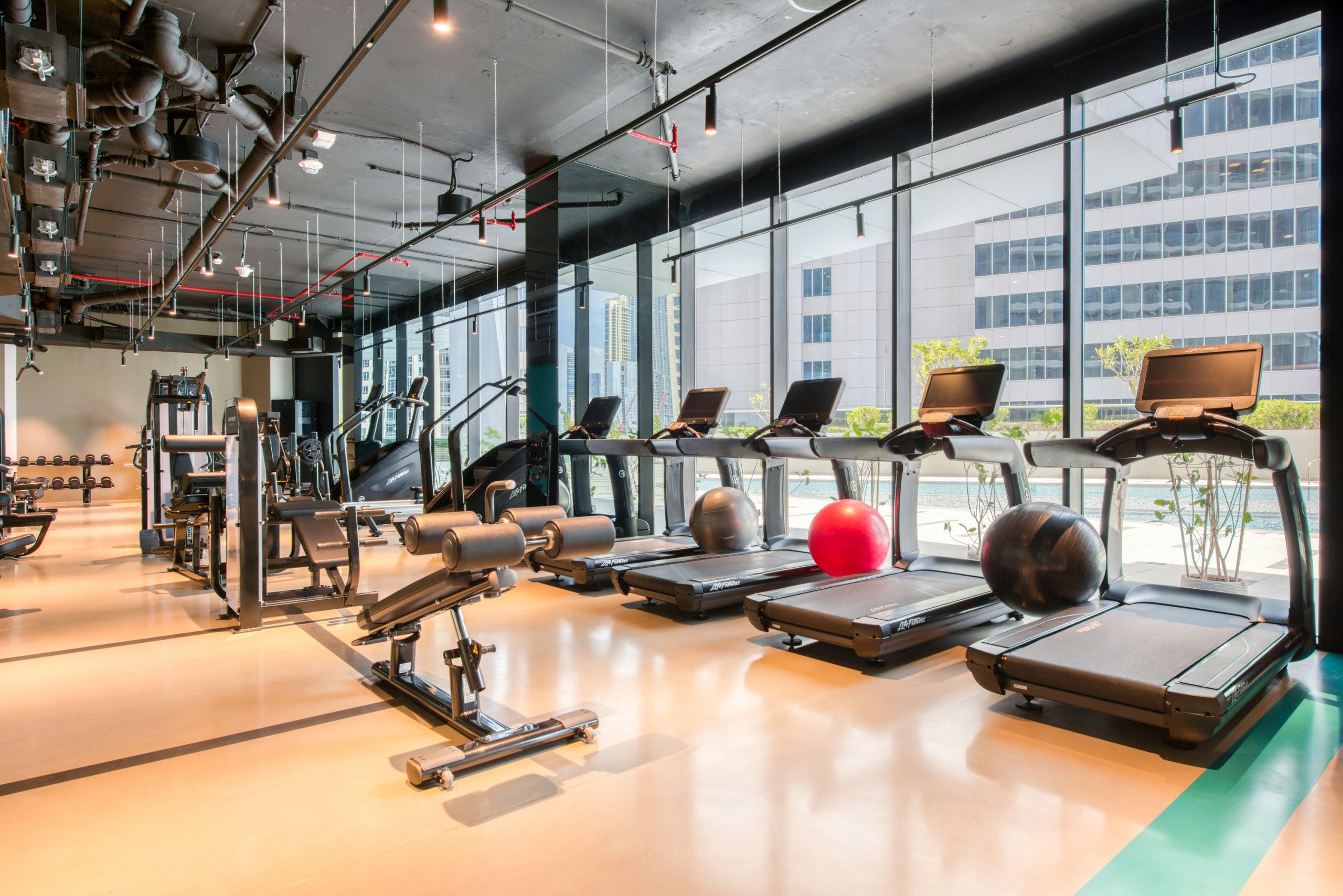 Une salle de sport équipée de tapis de course, de vélos elliptiques et de poids libres.