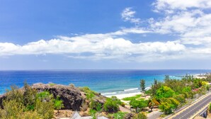 Una carretera costera con playa y terreno rocoso.