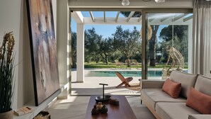 A modern living room with a sofa, a coffee table, and a painting on the wall.