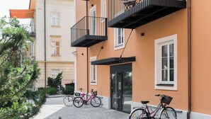 Un edificio con entrada a nivel de calle, un balcón y una bicicleta estacionada afuera.