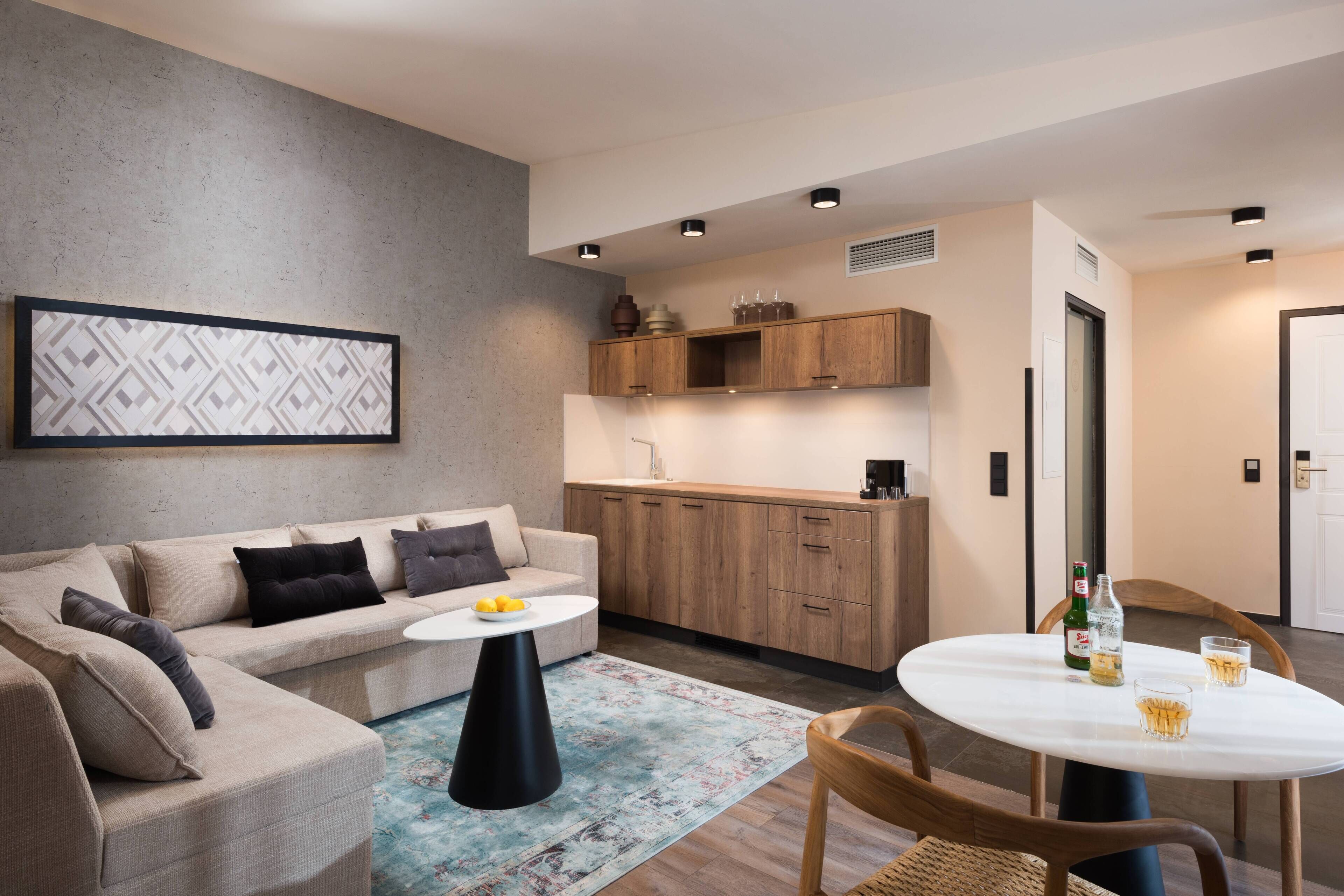 Ein modernes Wohnzimmer mit Sofa, Couchtisch und Essbereich mit Tisch und Stühlen.