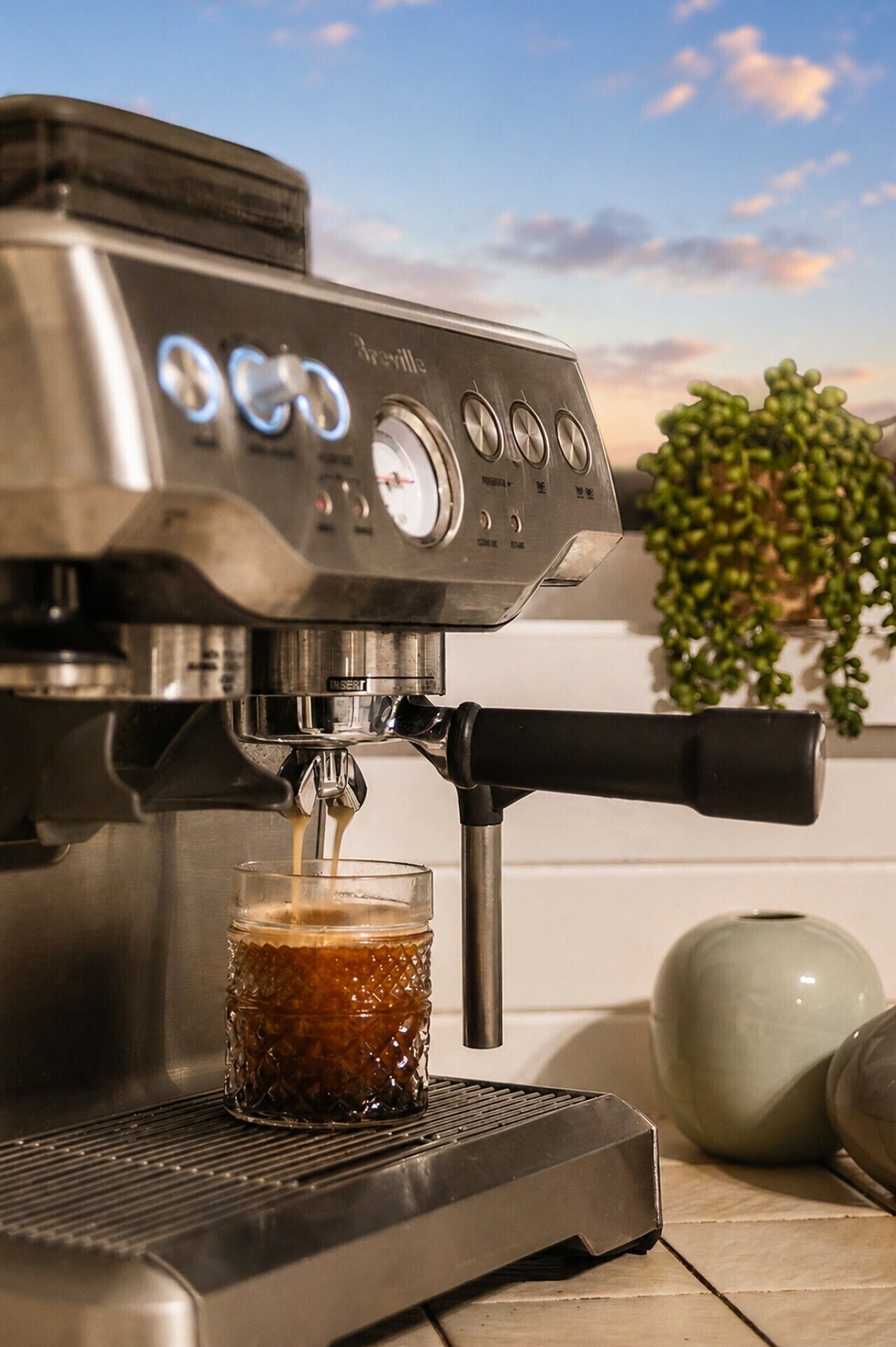 Une machine à expresso Breville verse du café dans un verre.