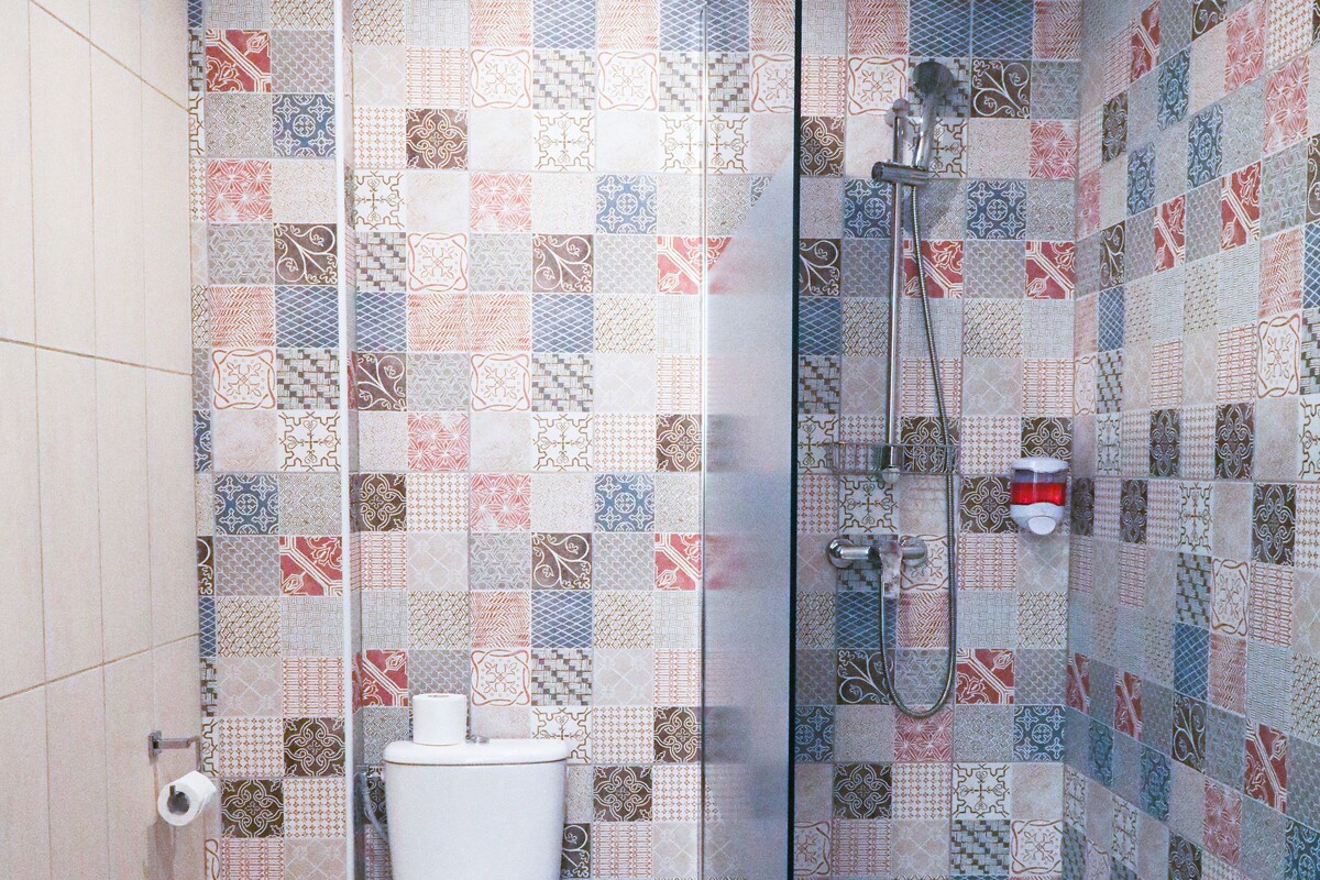A bathroom with a shower, toilet, and sink.