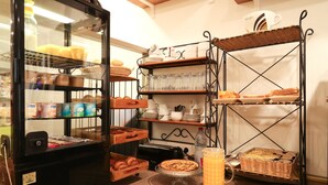 A bakery display with pastries, bread, and a coffee machine. - Hôtel GLORIA (Grenoble)