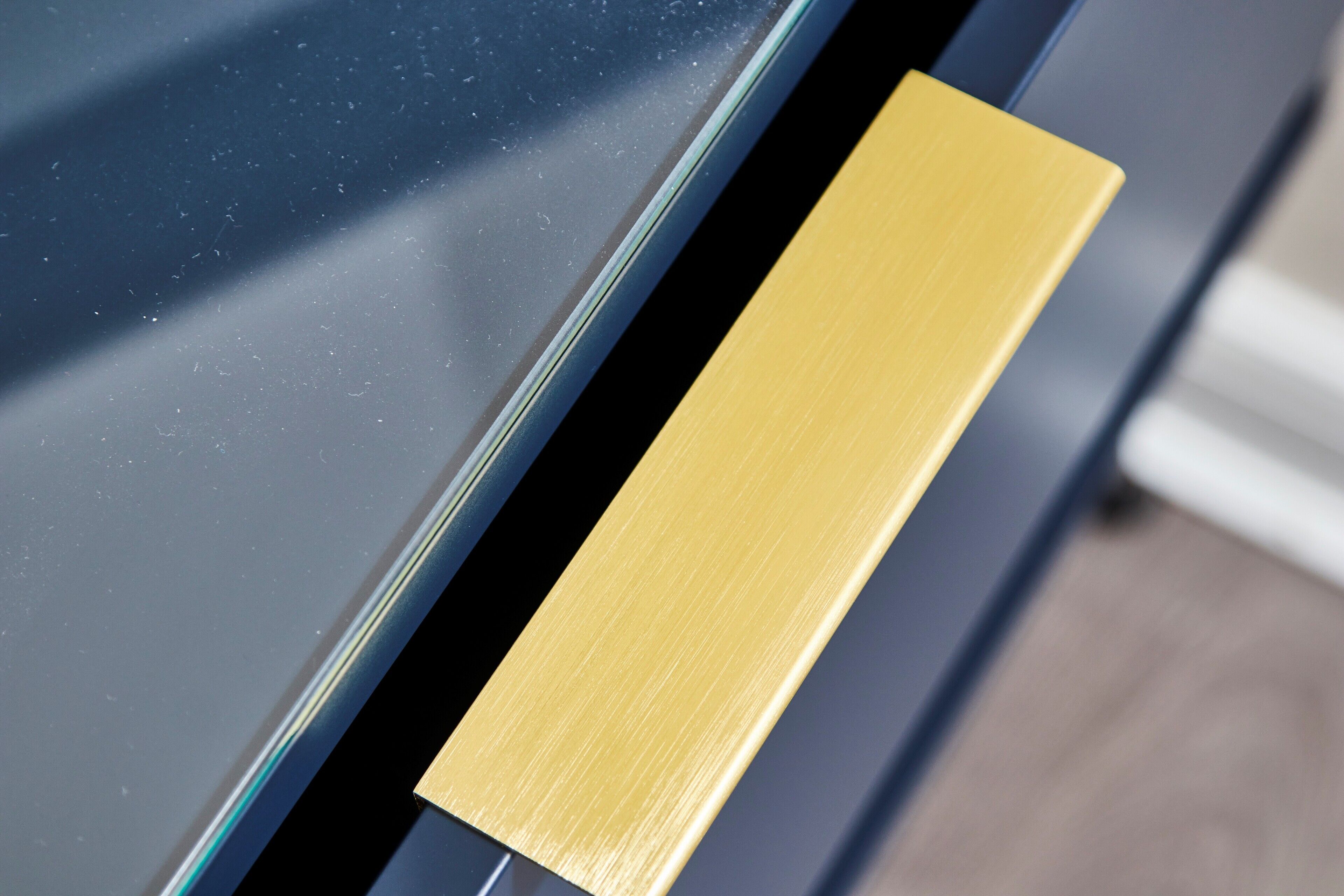 A close-up of a metallic handle on a door, with a reflective surface and a textured grip.