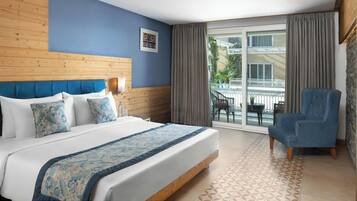 A hotel room with a bed, a chair, a window, and a view of the outside.
